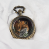 Closed locket casing with fox embroidery hidden inside.