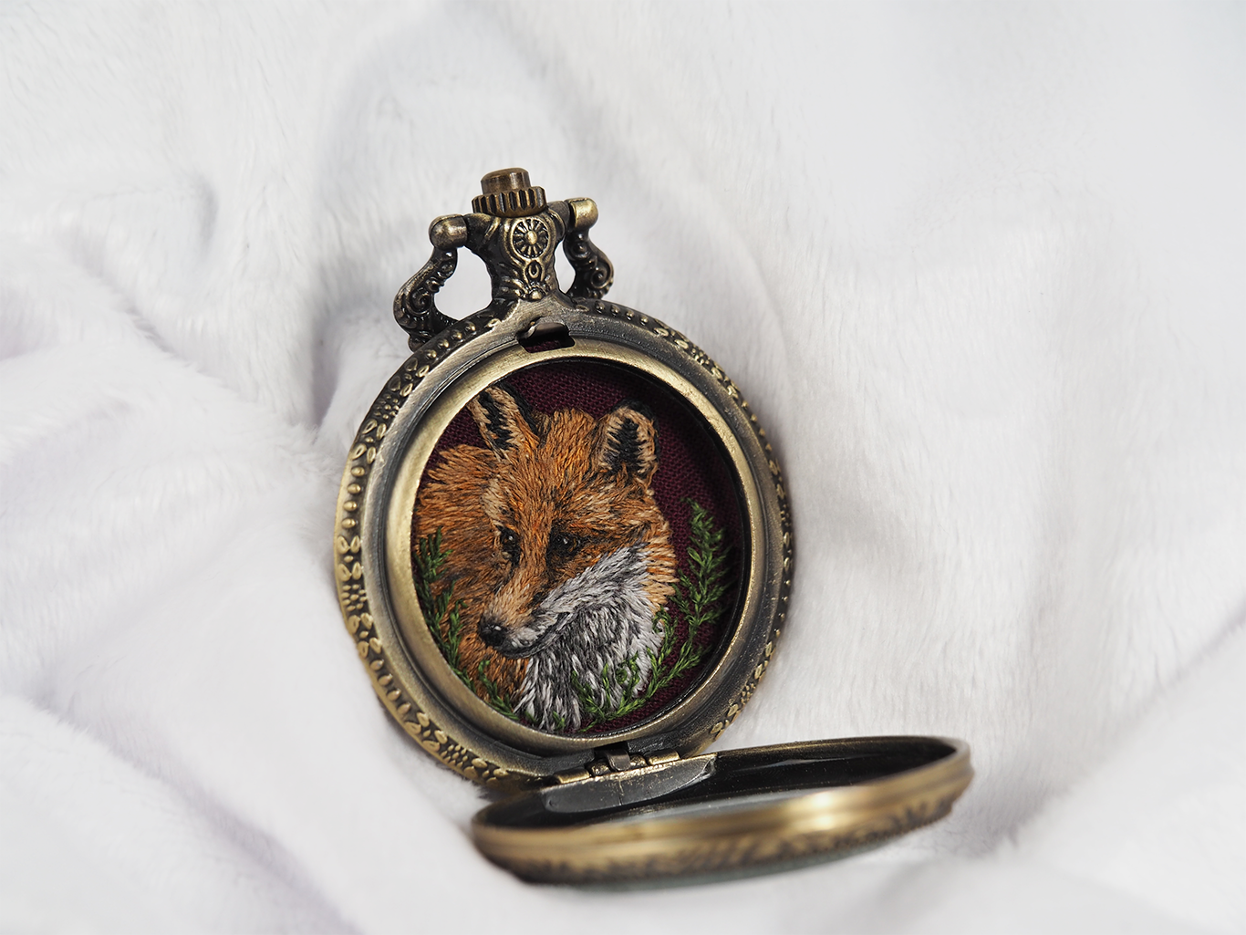Side view of open locket showing embroidered fox.