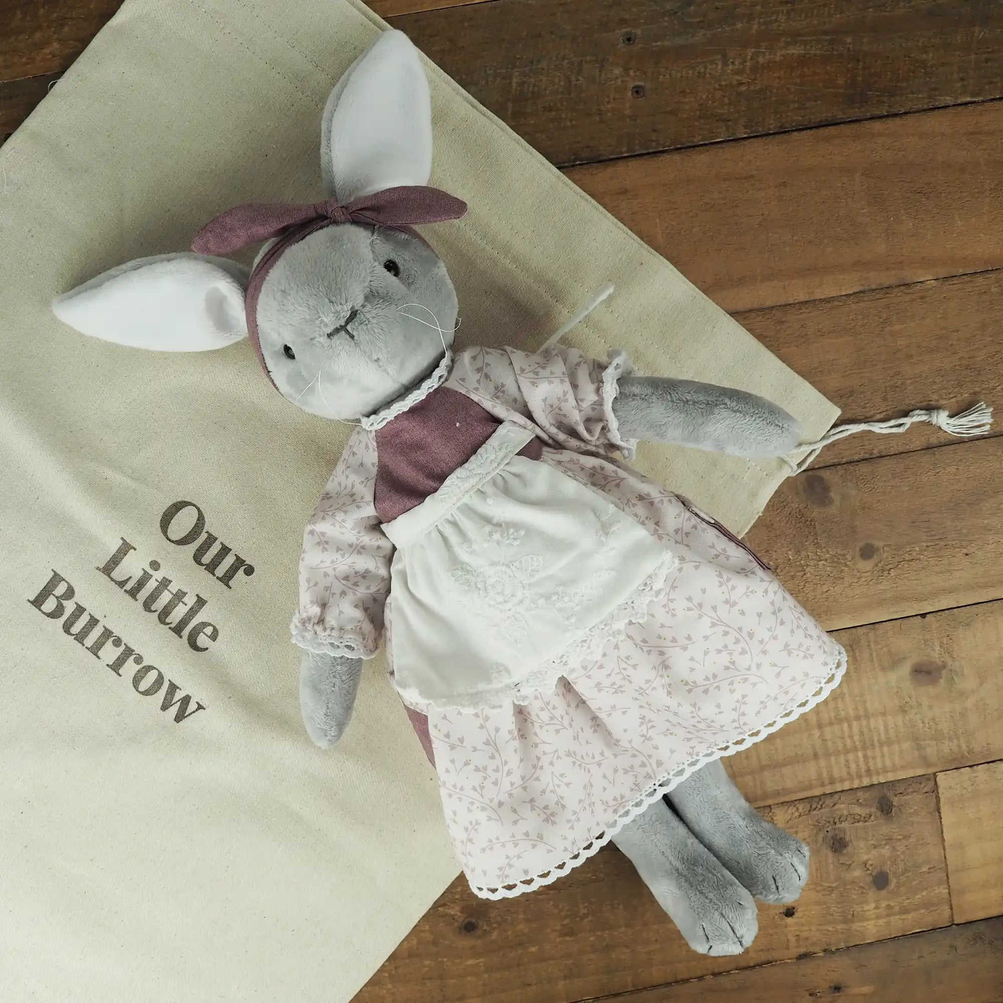 Flat lay photo of Burrowfolk rabbit Flossie, on an Our Little Burrow branded cloth bag.
