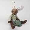 Burrowfolk rabbit, Freddie, sat in just his  green floral shirt and admiring his corduroy hat.
