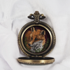 Fox portrait hand-embroidered inside an open locket, front view.
