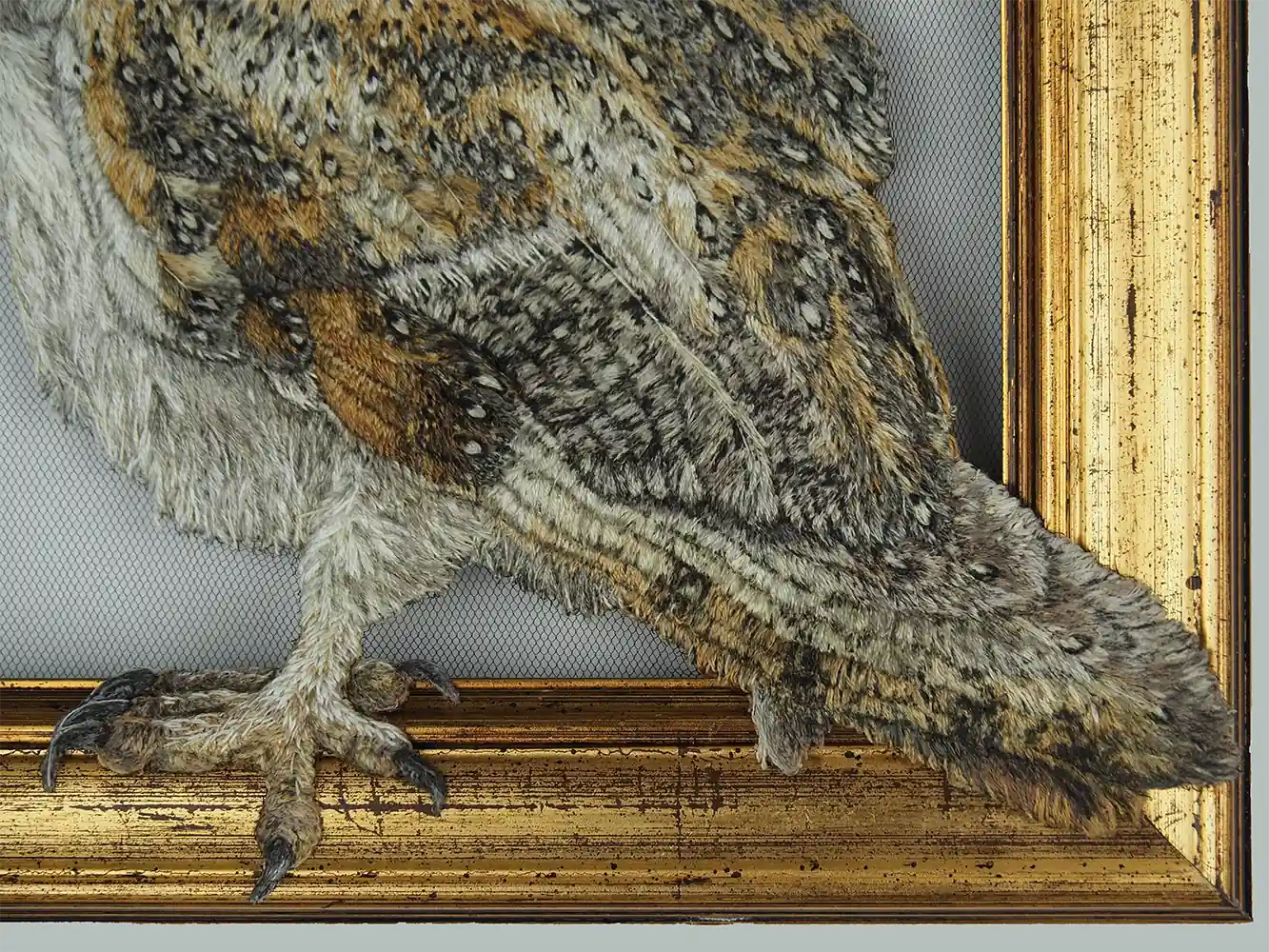 Detail of embroidered owl body and tail overlapping the picture frame.